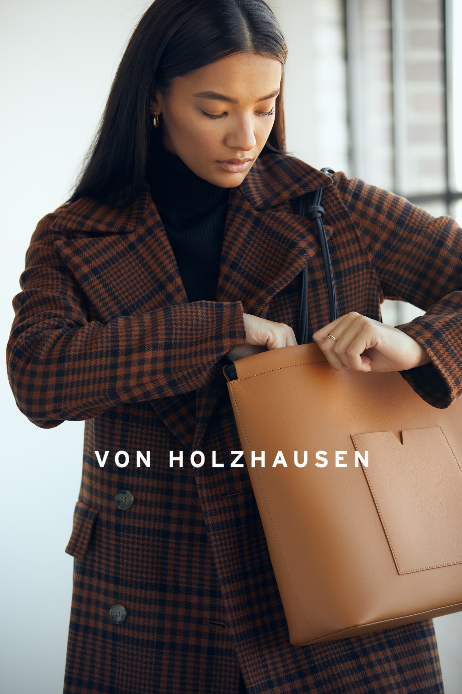 von Holzhausen campaign, model reaching into a tan leather tote